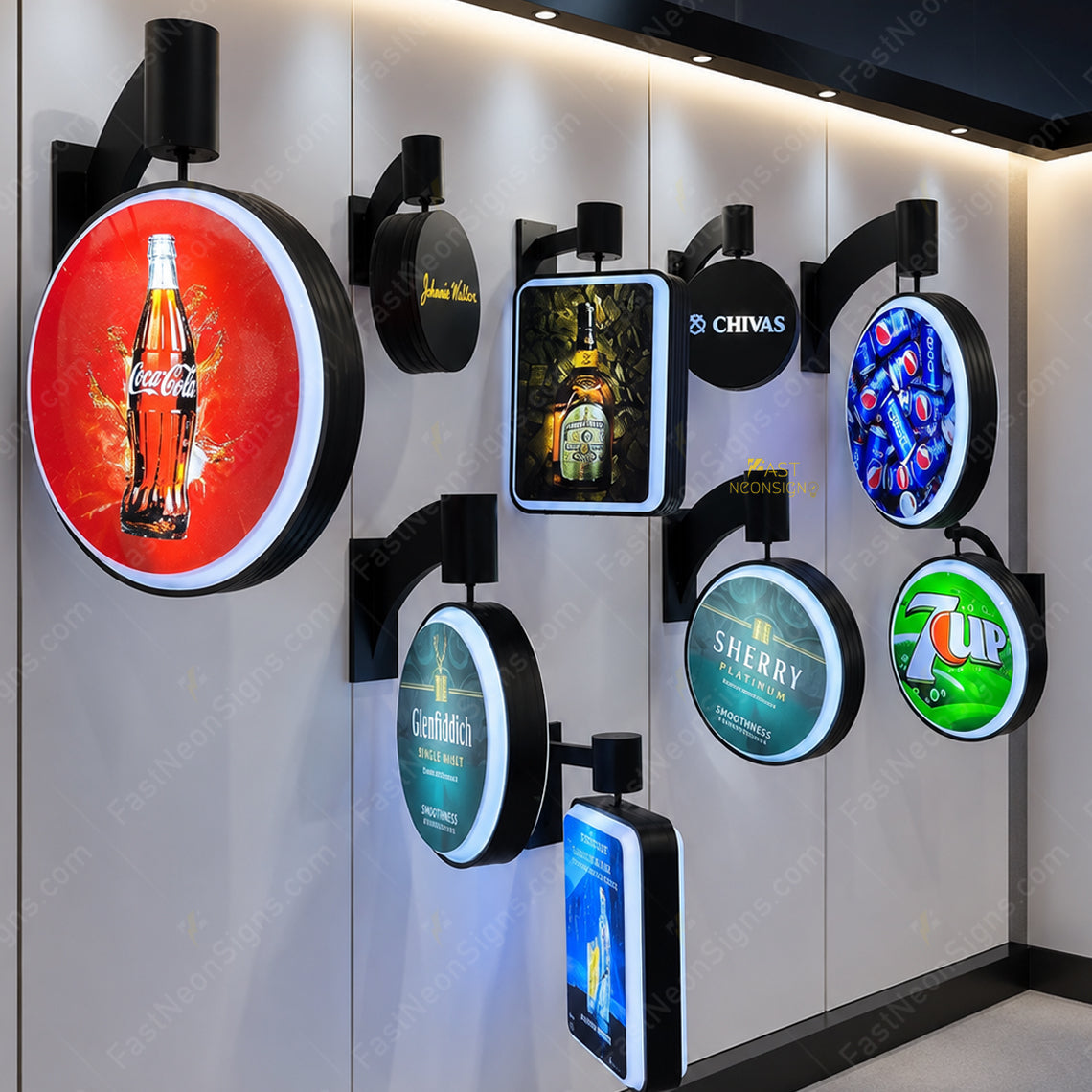 A wall-mounted display of multiple illuminated round and rectangular LED sign boards featuring different beverage logos, including Coca-Cola, Chivas, Pepsi, Sherry, 7UP, and Genghis Khan, set against a light gray paneled wall.